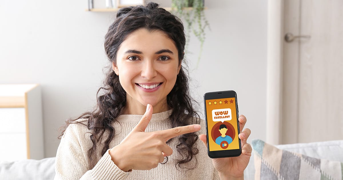 Young woman giving rating to new mobile application at home