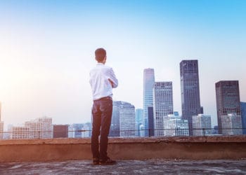 Businessman looking at cityscape with sunlight