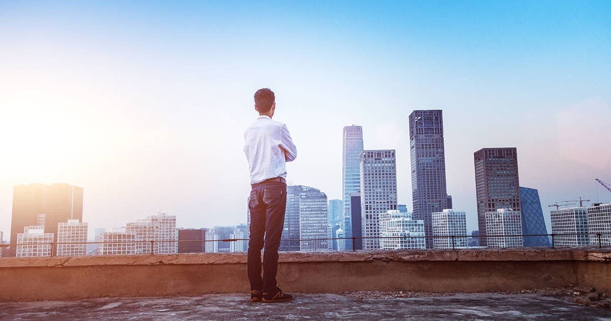 Businessman Looking At Cityscape With Sunlight