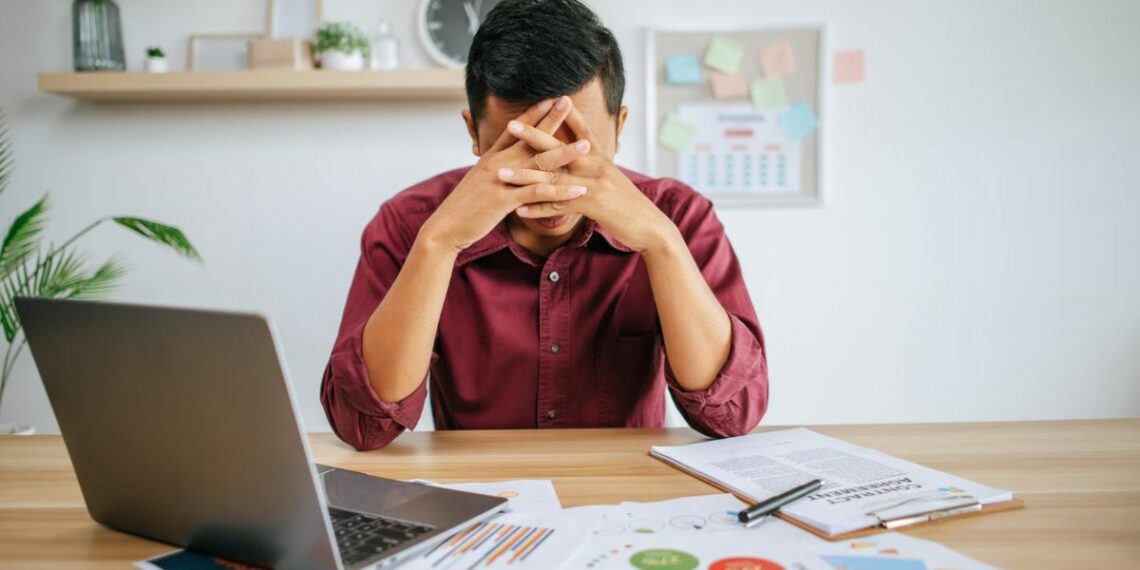 1200 Man Working With Laptop Paperwork With Stress