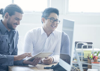 Two businessmen working with a digital tablet.