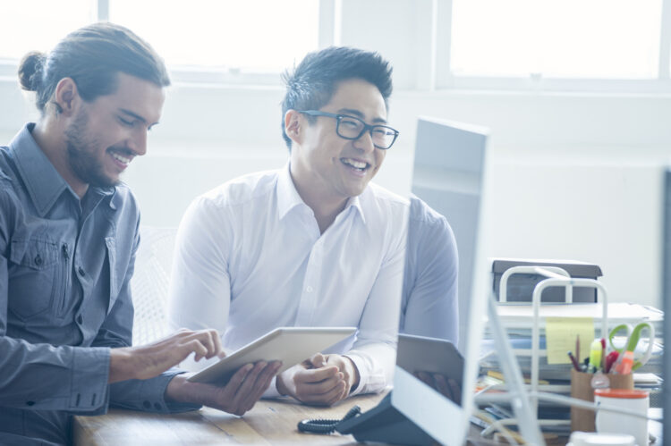 Two businessmen working with a digital tablet.